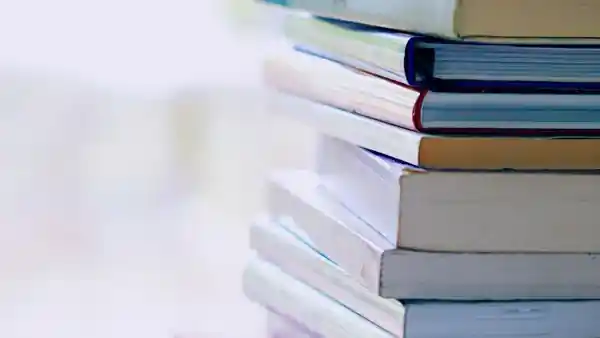 A stack of books with their pages facing outward.